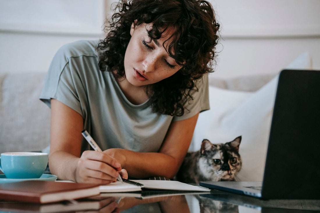 Cat owner shopping online with her cat beside her