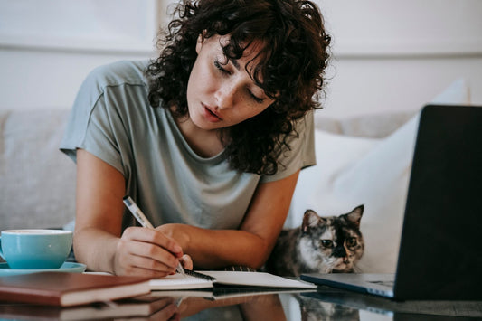 Cat owner shopping online with her cat beside her
